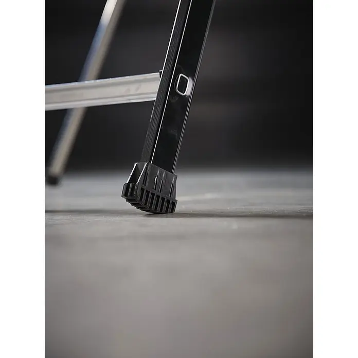 Altrex Podestleiter RolGuard Teleskop Plattformleiter Compact 5/7 Stufen - Arbeitshöhe: 3.600 m - Nahaufnahme eines schwarzen Leiterbeins mit geripptem schwarzem Gummifuß für Stabilität. Eine silberne Sprosse ist sichtbar.