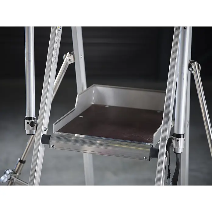 Altrex Podestleiter RolShield Plattformleiter 3 Stufen - Anzahl Tritte: 3 Stk., Arbeitshöhe: 2.700 m - Silberne Aluminium-Leiterplattform mit dunkelbrauner Anti-Rutsch-Oberfläche, integriert in eine Gerüststruktur.