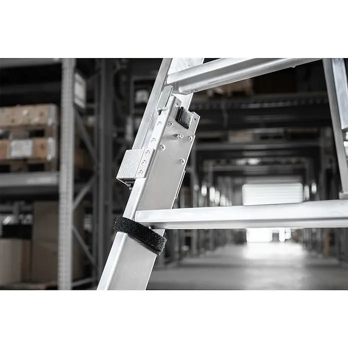 Munk Stehleiter Stufen Stehleiter Set beidseitig begehbar steckbar inkl. Einsteckteil 2x7 S - Anzahl Tritte: 7 Stk., Arbeitshöhe: 3.150 m, Belastbarkeit: 150 kg - Aluminium-Gelenkleiter mit Scharnier und schwarzem Gurt, in einer Lagerhalle fotografiert.