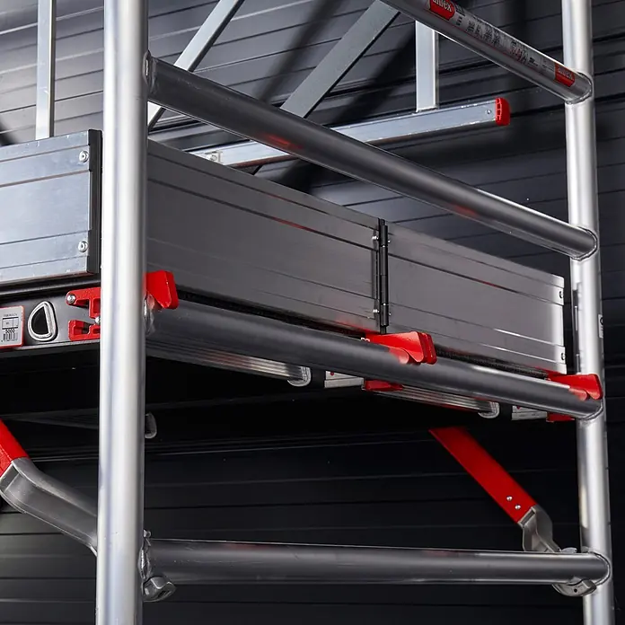 Altrex Rollgerüst RS Tower 55-S mit Safe-Quick® 6,8m Arbeitshöhe Holz-Plattform 2,45m - Arbeitshöhe: 6.800 m - Altrex Aluminiumgerüst: silberne Rohre, eine graue Klappplattform mit schwarzem Rand und rote Sicherheitsverschlüsse.