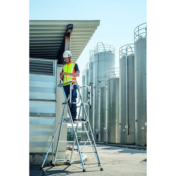 Zarges Teleskopleiter fahrbar gebördelte Teleskop Plattformleiter ZAP SAFEMASTER MAX S 3 Stufen - Anzahl Tritte: 3 Stk., Arbeitshöhe: 2.700 m, Belastbarkeit: 150 kg, Aluminium - Arbeiter auf einer Aluminium-Plattformleiter, mit PSA, bei Arbeiten in der Nähe von Industrietanks.