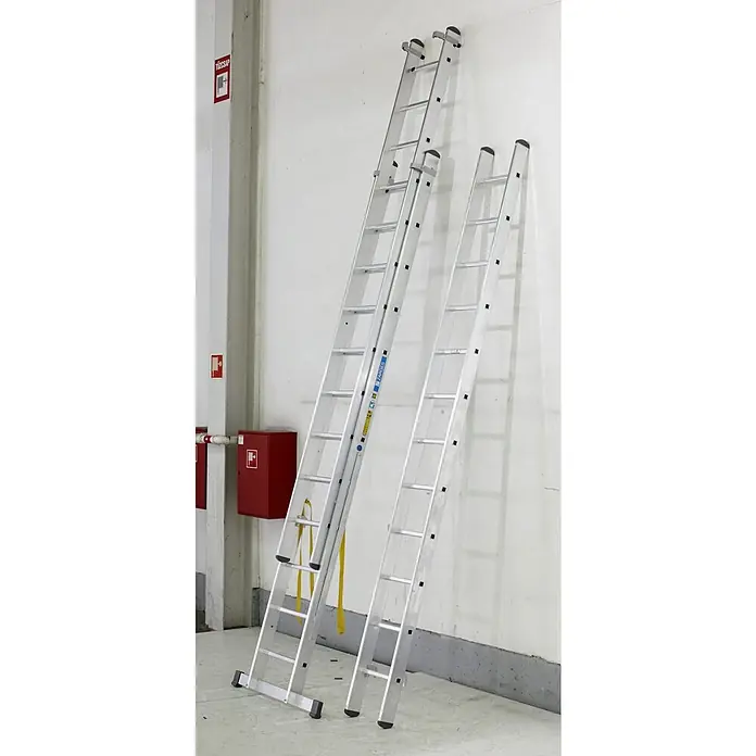 Zarges Mehrzweckleiter Skymaster X Mehrzweckleiter 3x10 Sprossen - Anzahl Tritte: 10 Stk., Arbeitshöhe: 7.650 m, Aluminium - Zwei silberne ZARGES Aluminiumleitern lehnen neben roter Brandschutzausrüstung.