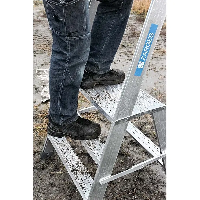 Zarges Arbeitsplattform Arbeitspodest Seventec RC SP 5 Stufen - Anzahl Tritte: 5 Stk., Arbeitshöhe: 3.080 m, Aluminium - Person auf einer Zarges Aluminium-Stehleiter mit rutschfesten Stufen.