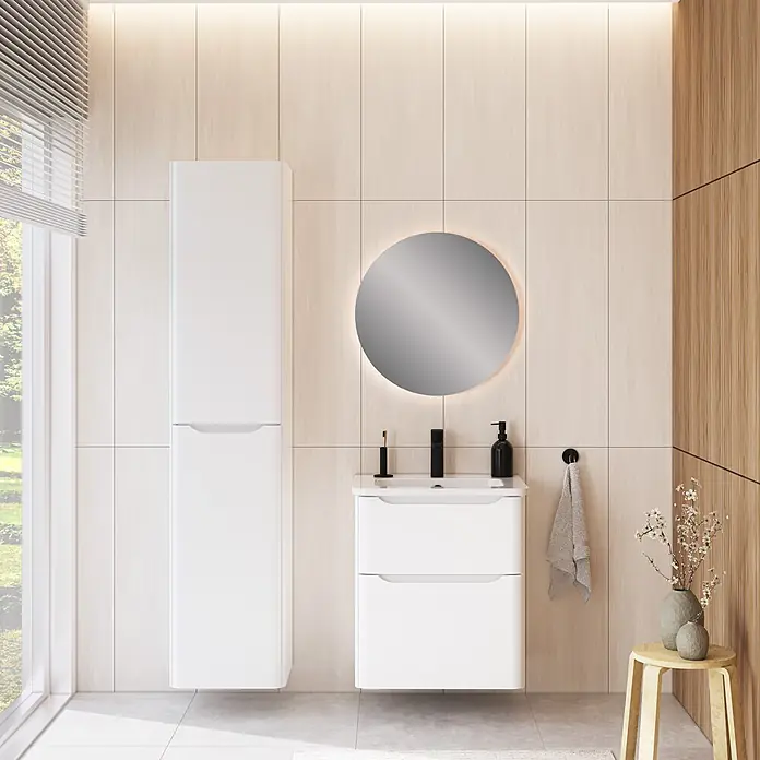VitrA Integra Round Badmöbel-Set - Gesamtbreite Badmöbel: 60 cm, Weiß, Matt - Modernes weißes Badmöbelset mit hohem Wandschrank, Waschtisch und rundem beleuchtetem Spiegel vor einer gefliesten Wand.
