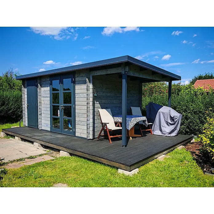 Fjordholz Gartenhaus Carin 44 C +SD - Außenmaß inkl. Dachüberstand (B x T): 606 x 320 cm, Holz, Kiefer/Pinie Imprägnierung - Holzgartenhaus mit hellen Wänden, dunkelgrauem Dach und integrierter dunkelgrauer überdachter Terrasse mit Gartenmöbeln.
