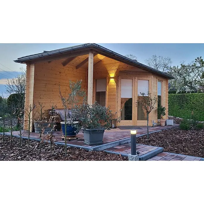 Fjordholz Gartenhaus Lisa 44 D Modern - Außenmaß inkl. Dachüberstand (B x T): 590 x 320 cm, Holz, Naturbelassen - Hölzernes Gartenhaus mit integrierter Terrasse und Außenbeleuchtung in einem Garten.
