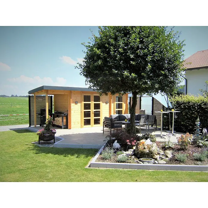 Fjordholz Gartenhaus Carin 44 A +SD - Außenmaß inkl. Dachüberstand (B x T): 606 x 220 cm, Holz, ohne Imprägnierung - Ein heller Holz-Gartenschuppen mit überdachter Terrasse, ausgestattet mit dunklen Gartenmöbeln, in einem sonnigen Garten.