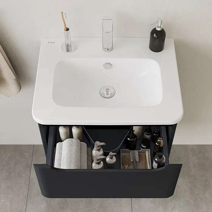 VitrA Integra Round Badmöbel-Set - Gesamtbreite Badmöbel: 60 cm, Graphit, Matt - Badezimmerschrank mit weißem Waschbecken und dunkelgrauem Unterschrank, Schublade geöffnet mit Toilettenartikeln.