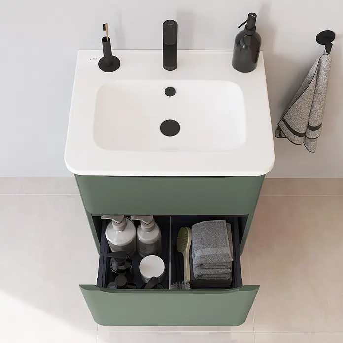 VitrA Integra Round Badmöbel-Set - Gesamtbreite Badmöbel: 60 cm, Moosgrün, Matt - Grüner Badezimmerschrank mit weißem Waschbecken und schwarzem Wasserhahn; Schublade offen mit Badutensilien und Handtüchern.