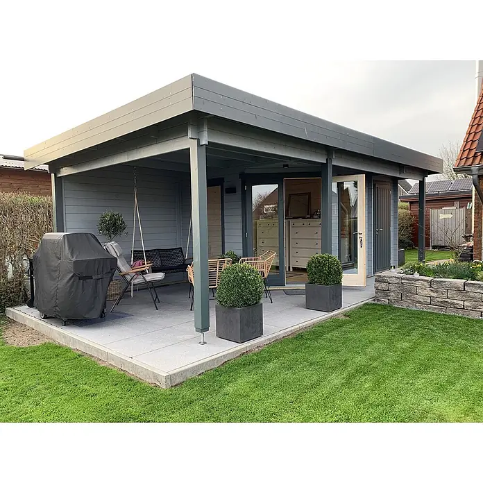Fjordholz Gartenhaus Nora 44 H Modern - Außenmaß inkl. Dachüberstand (B x T): 740 x 320 cm, Holz, Farbbehandlung Lichtgrau - Moderner grauer Holz-Gartenschuppen mit überdachter Terrasse und Gartenmöbeln, umgeben von Rasen und Beeten.