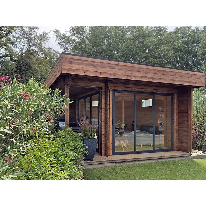 Fjordholz Gartenhaus - Außenmaß inkl. Dachüberstand (B x T): 448 x 398 cm, Holz, Grau Imprägnierung - Braunes Gartenhaus aus Holz mit großen Glasschiebetüren und Flachdach in einem grünen Garten.