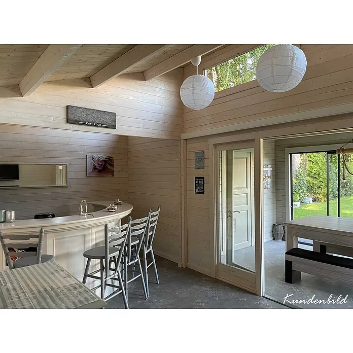 Fjordholz Gartenhaus - Außenmaß inkl. Dachüberstand (B x T): 670 x 655 cm, Holz, Farbbehandlung Schwedenrot - Innenansicht eines hellen Holzgartenhauses mit Bar, Hockern und Esstisch, als gemütlicher Freizeitbereich gestaltet.