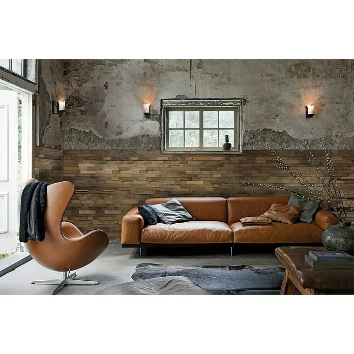Indo Wandpaneel 3D Wall Charred - Teak, 500 x 200 x 10 mm, 1 m² - Ein modernes Wohnzimmer mit einem braunen Ledersofa, einem Sessel und einer Holzwand, die eine warme und einladende Atmosphäre schafft.