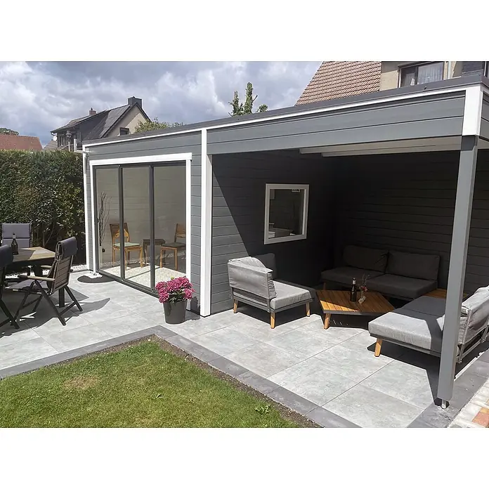 Fjordholz Gartenhaus Q-BIC Alu 44 A + SD 6mm Einfachglas - Außenmaß inkl. Dachüberstand (B x T): 680 x 380 cm, Holz, ohne Imprägnierung - Moderne graue Gartenhütte mit integrierter Pergola und weißer Zierleiste, schafft stilvollen Außenwohnbereich auf gefliester Terrasse.
