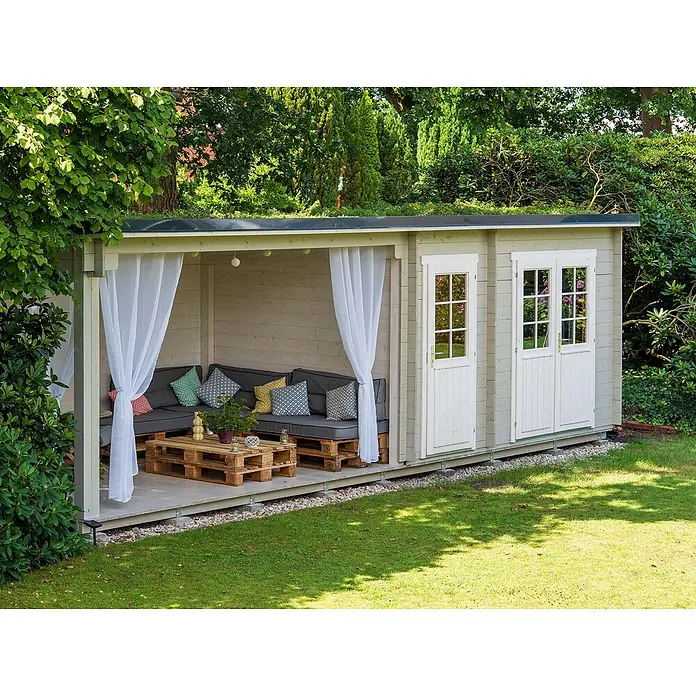 Fjordholz Gartenhaus Gent 28 D Farbbehandlung Lichtgrau - Außenmaß inkl. Dachüberstand (B x T): 781 x 298 cm, Holz, Naturbelassen - Helles Gartenhaus mit integrierter überdachter Lounge, grauen Palettensofa und weißen Vorhängen im grünen Garten.