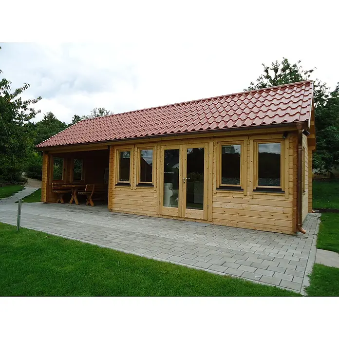 Fjordholz Gartenhaus Teehaus Kensington 70 - Außenmaß inkl. Dachüberstand (B x T): 930 x 400 cm, Holz, Farbbehandlung Schwedenrot - Hölzernes Gartenhaus mit rotem Ziegeldach, überdachter Terrasse mit Sitzgelegenheiten und großen Glastüren, auf einer gepflasterten Fläche im Garten.