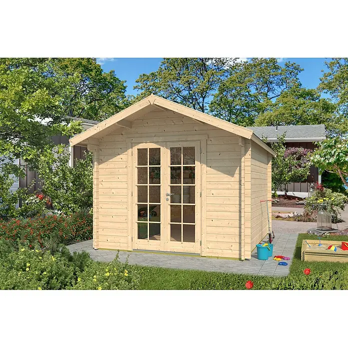 Fjordholz Gartenhaus Lexi 44 E Premium Ganzglas-Tür Farbbehandlung Carbongrau - Außenmaß inkl. Dachüberstand (B x T): 280 x 320 cm, Holz, Naturbelassen - Ein heller Holzgartenschuppen mit Doppeltüren aus Glas auf einer gepflasterten Fläche in einem sonnigen Garten.