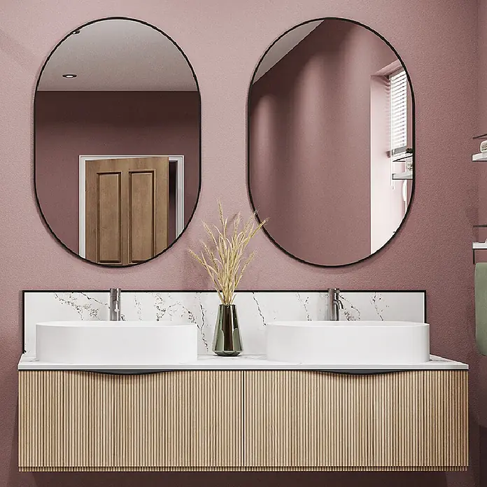 Wetwall Wandpaneel Alloy Spritzschutz - 25 x 80 cm, Calacatta Volegno - Moderner Doppelwaschtisch mit zwei weißen Aufsatzwaschbecken, geripptem Holzschrank, Marmor-Arbeitsplatte und zwei schwarz gerahmten ovalen Spiegeln.