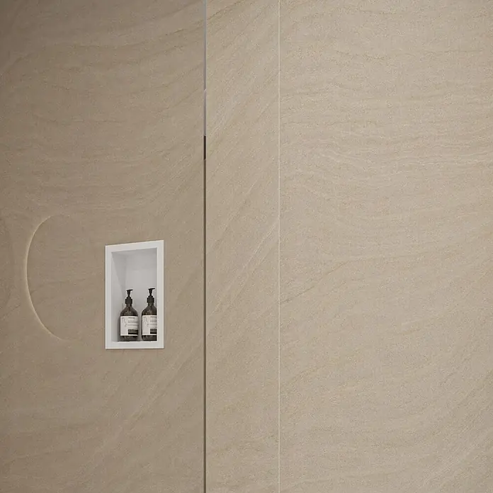 Wetwall Wandpaneel Elite - 16 x 242 cm, Sandstone, Abgerundete Kante - Weiße Duschablage mit zwei braunen Seifenflaschen in einer beigefarbenen, texturierten Duschwand.