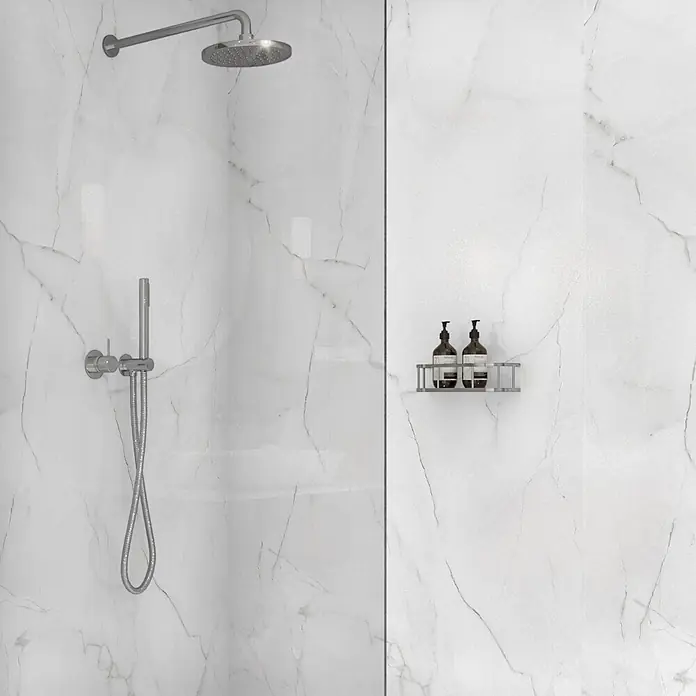 Wetwall Wandpaneel Elite - 16 x 242 cm, Athena Marble, Abgerundete Kante - Moderne Dusche mit weißen Marmoroptik-Fliesen, Chrom-Kopf- und Handbrause, und einem Metallregal für Toilettenartikel.