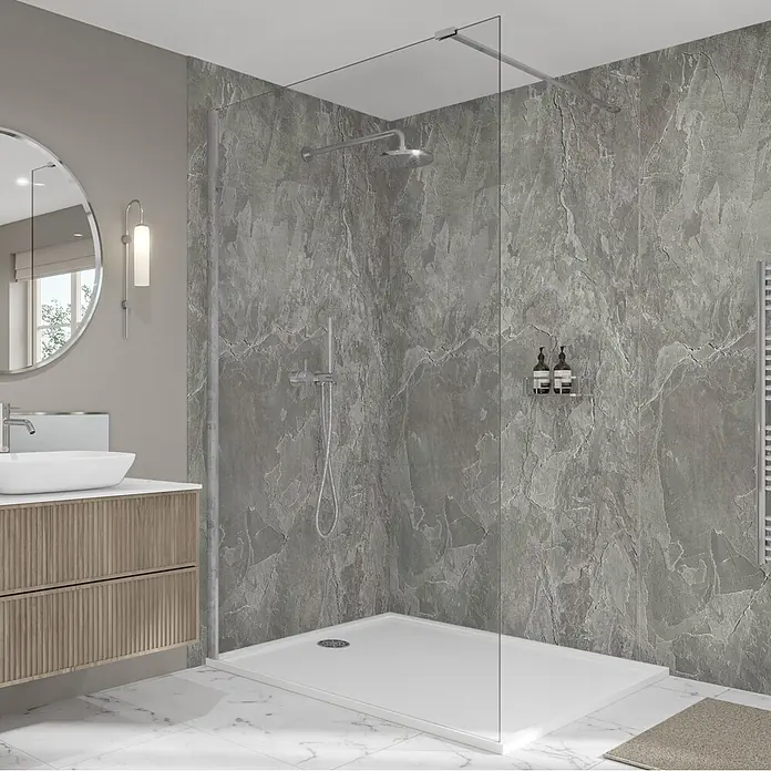 Wetwall Wandpaneel Elite - 120 x 242 cm, Scafell Slate, Nut & Feder System - Ein modernes Badezimmer mit einer begehbaren Dusche, klarem Glaswand, weißer Duschwanne und grauen Steinwandpaneelen, neben einem Holzwaschtisch.