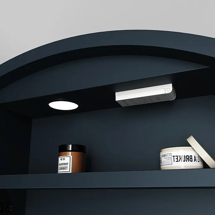 Disbain Armario con espejo LED Mali - Diámetro: 80 cm, Aluminio, Antracita - Armario arqueado azul oscuro, iluminado internamente, con tarro de crema de pomelo marrón y tarro de exfoliante facial claro abierto.