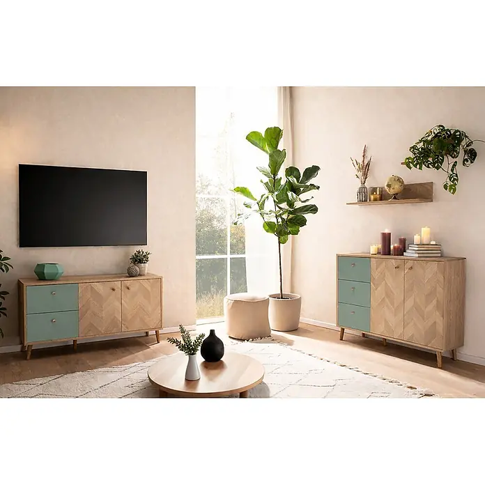 Schildmeyer Visby Wandregal-Set - 2 Stk., Eiche - Zwei helle Holz-Sideboards mit Fischgrätmuster-Türen und mintgrünen Schubladen, eines unter einem TV, das andere mit Deko in einem hellen Wohnzimmer.