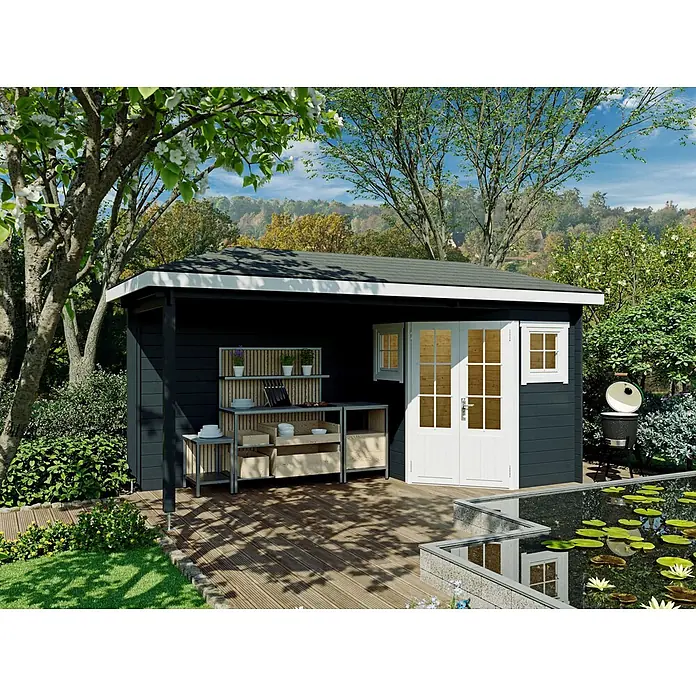 Fjordholz Gartenhaus Evelyn 1C - Außenmaß inkl. Dachüberstand (B x T): 500 x 200 cm, Holz, Naturbelassen - Dunkelgrauer Gartenpavillon mit weißen Türen und integrierter Außenküche auf Holzterrasse, in üppigem Garten mit Teich.
