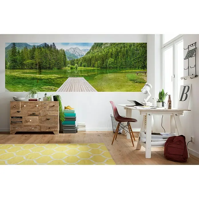Komar Fototapete Green Lake - 4 -tlg., B x H: 368 x 127 cm, Papier - Eine geräumige Inneneinrichtung mit einem großen Landschaftswandbild über einer rustikalen Holzkommode, das dem Raum Natur und Wärme verleiht.