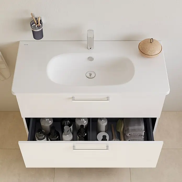 VitrA Badmöbel-Set Root Flat - B x T x H: 100 x 45 x 65 cm, Weiß, Hochglänzend - Weißer Badunterschrank mit integriertem Waschbecken und offener Schublade, die Toilettenartikel und Handtücher zeigt.