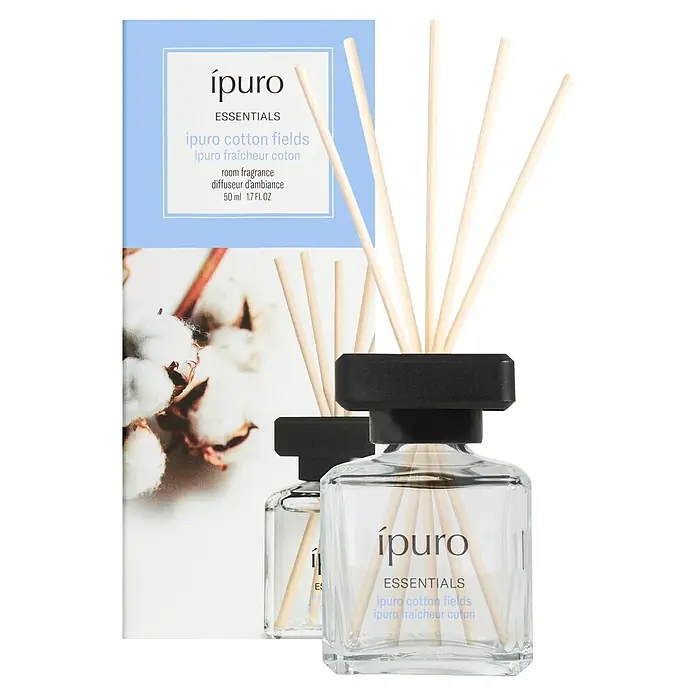 Ipuro Essentials Raumduft - Cotton Fields, 50 ml - Zwei ipuro Raumdüfte mit klaren Glasflaschen, schwarzen Kappen und Holzstäbchen, zusammen mit ihrer hellblauen und weißen Produktverpackung.