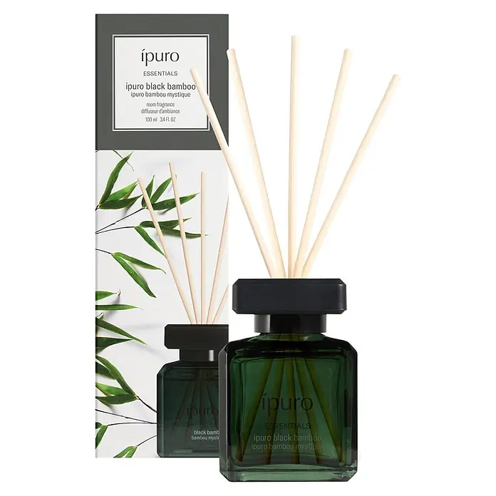 Ipuro Essentials Raumduft - Black Bamboo, 100 ml - Ein ipuro Black Bamboo Raumduft-Diffusor mit dunkelgrüner Glasflasche, schwarzer Kappe und Holzstäbchen, zusammen mit seiner Verpackung.