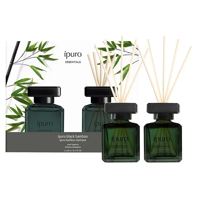 Ipuro Essentials Raumduft Set - Black Bamboo, 2 Stk., 50 ml - Ipuro Black Bamboo Raumduft-Set mit grünen Glasdiffusoren, schwarzen Kappen und Holzstäbchen, zusammen mit seiner Verpackung.