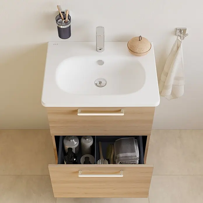 VitrA Badmöbel-Set Root Flat - Gesamtbreite Badmöbel: 60 cm, Eiche Natur - Helles Holz Badunterschrank mit weißem Waschbecken, offene Schublade zeigt Toilettenartikel.