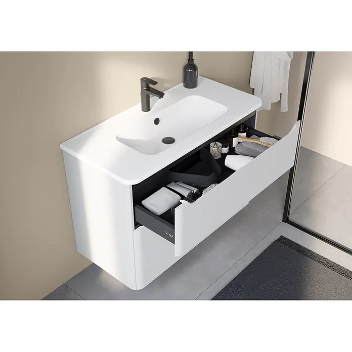 VitrA Integra Round Badmöbel-Set - Gesamtbreite Badmöbel: 100 cm, Hellgrau, Matt - Weiße Wandwaschtisch mit integriertem Becken, schwarzer Armatur und offener Schublade mit Pflegeprodukten.