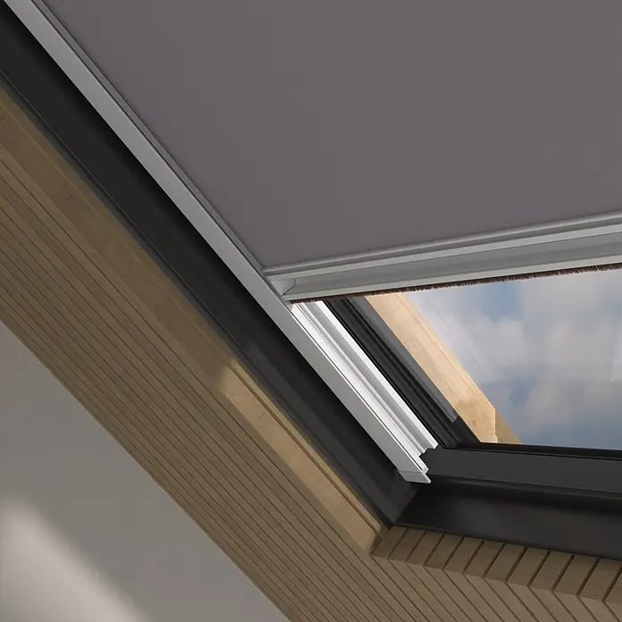 Dachfensterrollo Sky 2.0 - S06, Grau, Manuell - Dunkelgraues Stoff-Verdunkelungsrollo an einem Holz-Dachfenster, das die Scheibe teilweise bedeckt.