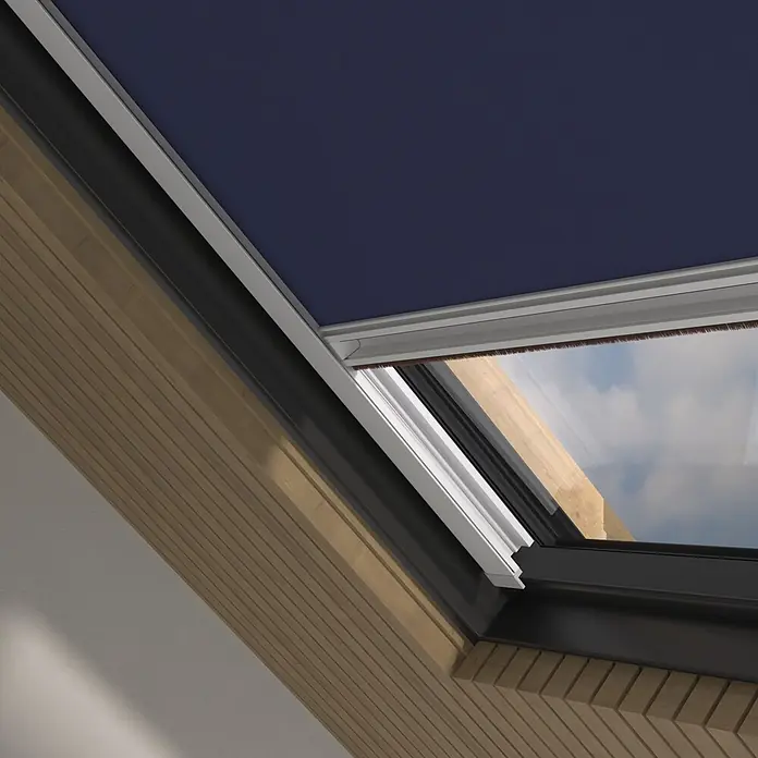 Dachfensterrollo Sky 2.0 - C02, Dunkelblau, Manuell - Dunkelblaues Dachfensterrollo teilweise ausgefahren in Holz-Dachfenster, Himmel sichtbar.