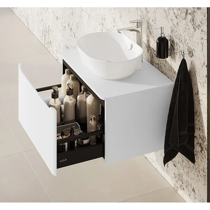 VitrA Integra Round Waschtischunterschrank Integra Round - B x T x H: 76,5 x 52 x 42 cm, Hellgrau - Weißer Badunterschrank mit Aufsatzwaschbecken und geöffneter Schublade voller Pflegeprodukte, vor einer marmorierten Wand.