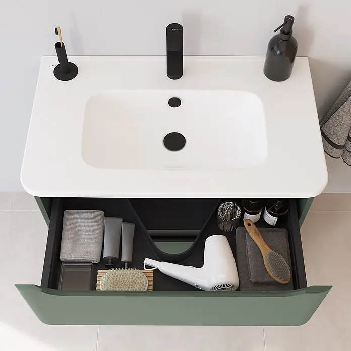 VitrA Integra Round Badmöbel-Set - Gesamtbreite Badmöbel: 80 cm, Moosgrün, Matt - Weißes Waschbecken mit schwarzer Armatur, Zahnbürstenhalter und Seifenspender, über einem grünen Waschtisch mit offener Schublade voller Pflegeprodukte und Handtücher.
