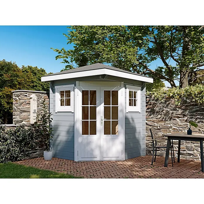 Fjordholz Gartenhaus Evelyn 1A - Außenmaß inkl. Dachüberstand (B x T): 200 x 200 cm, Holz, Naturbelassen - Ein hellgraues Eck-Gartenhaus mit weißen Türen und Fenstern und einem dunkelgrauen Dach auf einer roten Ziegelterrasse in einem grünen Garten.