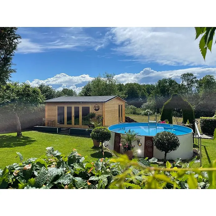Fjordholz Gartenhaus Davos 70 B - Außenmaß inkl. Dachüberstand (B x T): 578 x 534 cm, Holz, Kiefer/Pinie Imprägnierung - Ein heller Holzgartenpavillon mit dunklem Dach und Glastüren, neben einem runden blauen Aufstellpool in einem sonnigen Garten.