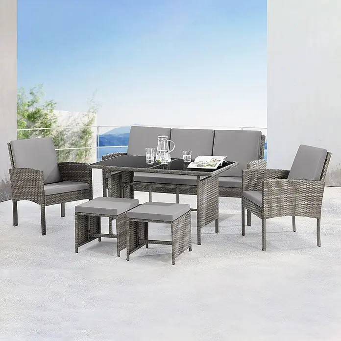 SVITA Loungemöbel-Set DENVER - Polyrattan, Grau - Graues Rattan-Gartenmöbelset mit Sofa, zwei Stühlen, zwei Hockern und Glastisch auf einer Terrasse mit Bergblick.