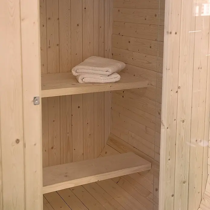 Home Deluxe Fasssauna CUBE S - Elektroofen, Holz - Helles Holzinterieur mit zwei Regalböden, der obere trägt sauber gefaltete weiße Handtücher.