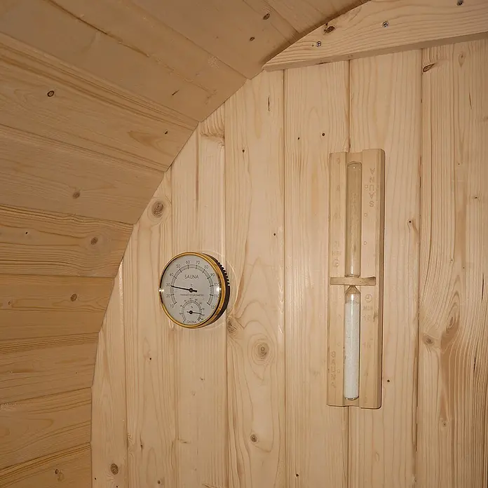 Home Deluxe Fasssauna CUBE L - Elektroofen, Holz - Sauna Thermometer/Hygrometer und hölzerne Sanduhr an heller Holzwand, zeigen Temperatur, Feuchtigkeit und Zeit.