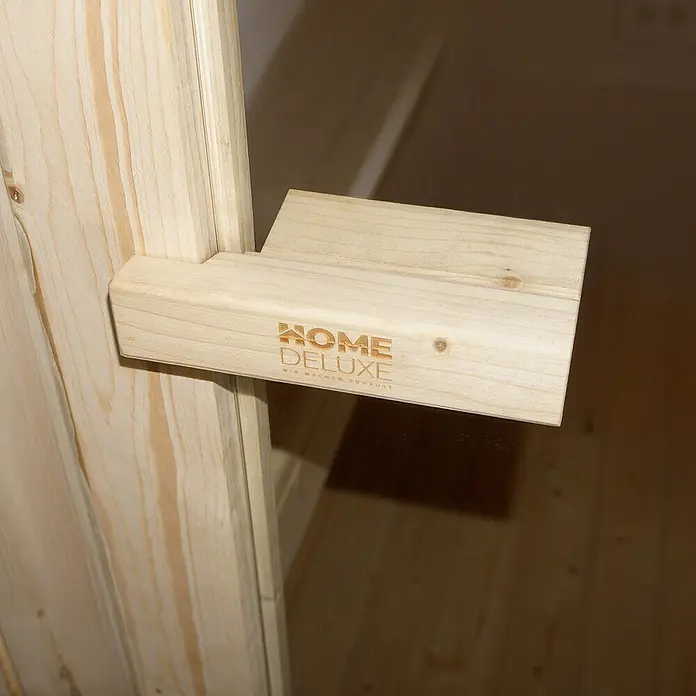 Home Deluxe Fasssauna CUBE M - Elektroofen, Holz - Helle Holzhalterung mit 'HOME DELUXE' Logo, an einer Holzkonstruktion befestigt.