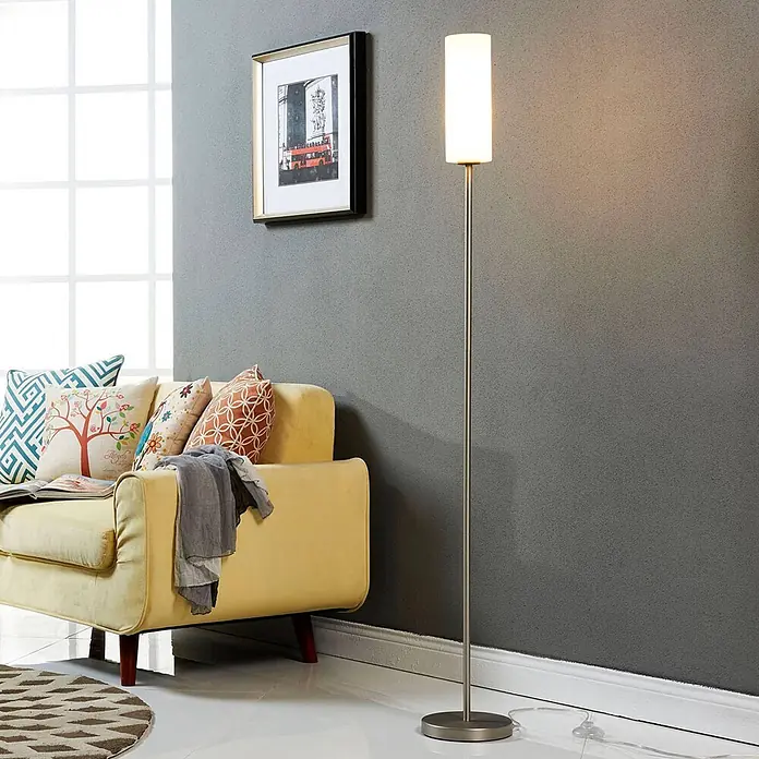 Lindby Stehleuchte Vinsta - alu / grau / zink, weiß / opal, E27 - Schlanke Stehleuchte mit gebürstetem Metallschaft und weißem Zylinderschirm, die ein modernes Wohnzimmer neben einem gelben Sofa beleuchtet.