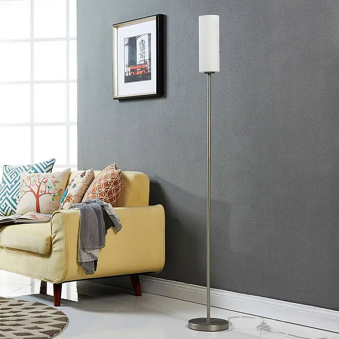 Lindby Stehleuchte Vinsta - alu / grau / zink, weiß / opal, E27 - Hohe Stehleuchte mit gebürsteter Metallstange und zylindrischem weißem Schirm, neben einem gelben Sofa.