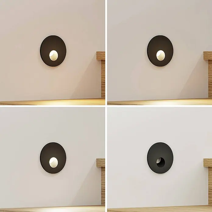 Arcchio Wandleuchte Vexi - L x B x H: 7,5 x 7,5 x 4,5 cm, schwarz - Runde dunkle Einbauwandleuchte mit warmem Abwärtslicht, über einer Holzfläche montiert.