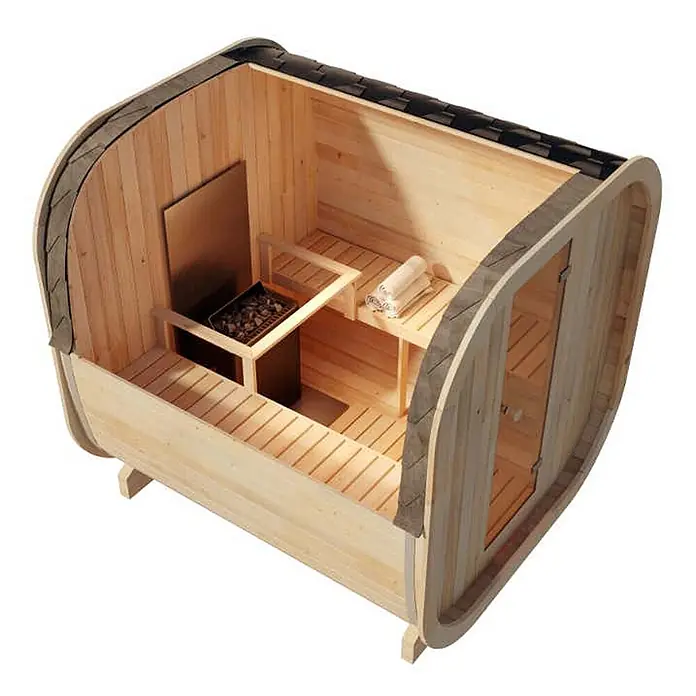 FinnTherm Fasssauna ScandiCube Comfort - Holz - Heller Holz-Fasssauna-Innenraum mit Bänken, einem Metallofen mit Steinen und gefalteten Handtüchern.
