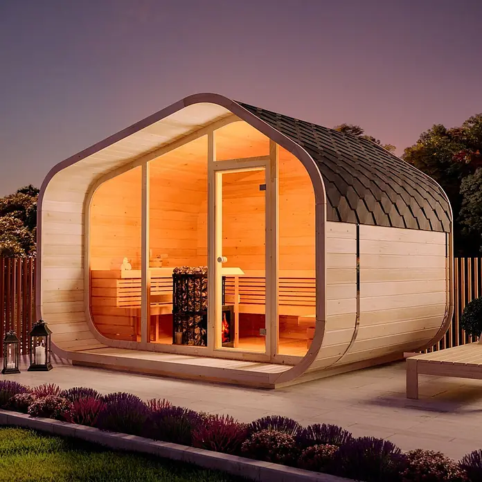 FinnTherm Fasssauna ScandiCube Wave Premium - Holz, L x B x H: 286 x 38 x 264 cm - Moderne Gartensauna aus hellem Holz mit dunklem Schindeldach und beleuchteter Glasfront, im Garten bei Dämmerung.